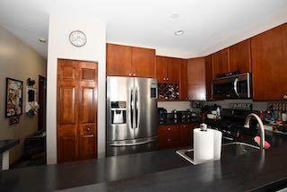 kitchen with stainless steel appliances, dark countertops, a sink, and a peninsula