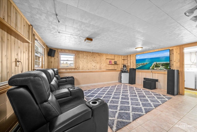 living area with light tile patterned floors, washer / clothes dryer, and wood walls