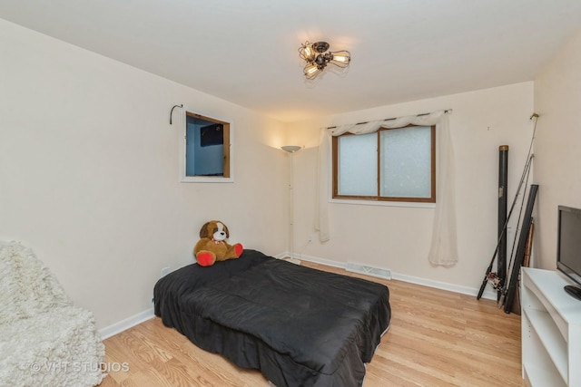 bedroom with light wood-type flooring, baseboards, and visible vents