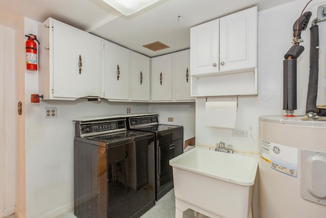 laundry room featuring a sink, cabinet space, baseboards, electric water heater, and independent washer and dryer