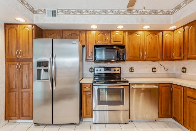 kitchen featuring brown cabinets, light countertops, stainless steel appliances, and visible vents