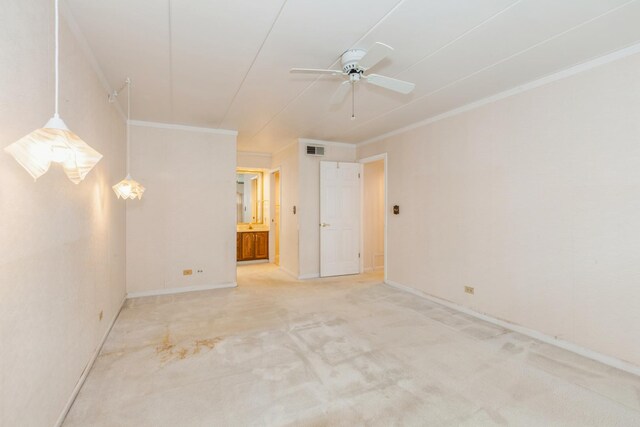carpeted spare room with crown molding, baseboards, a ceiling fan, and visible vents