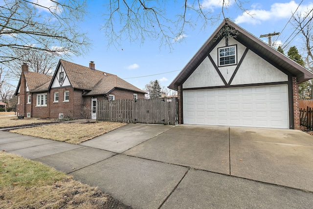 view of home's exterior featuring brick siding, an outdoor structure, fence, and stucco siding