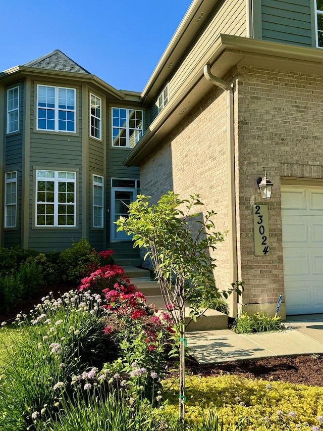 view of side of home featuring brick siding and an attached garage