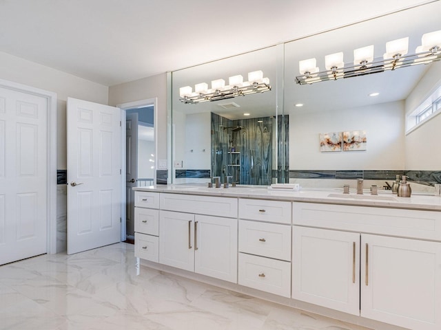 full bathroom featuring double vanity, marble finish floor, a shower stall, and a sink