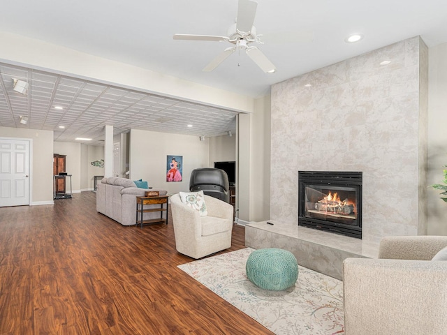 living room featuring recessed lighting, baseboards, wood finished floors, and a high end fireplace