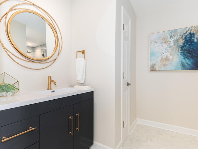 bathroom with marble finish floor, vanity, and baseboards