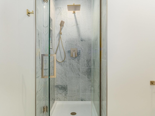 bathroom featuring a marble finish shower