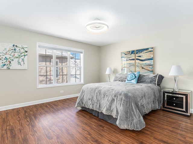 bedroom featuring baseboards and dark wood-style flooring