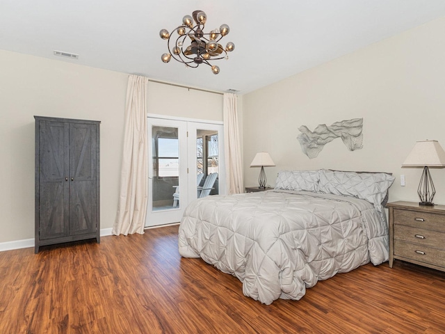 bedroom featuring access to exterior, visible vents, a chandelier, and wood finished floors