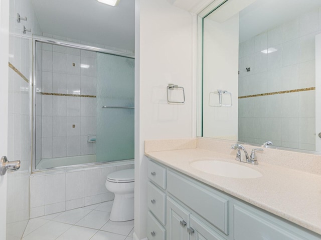 full bath featuring vanity, tiled shower / bath, toilet, and tile patterned floors