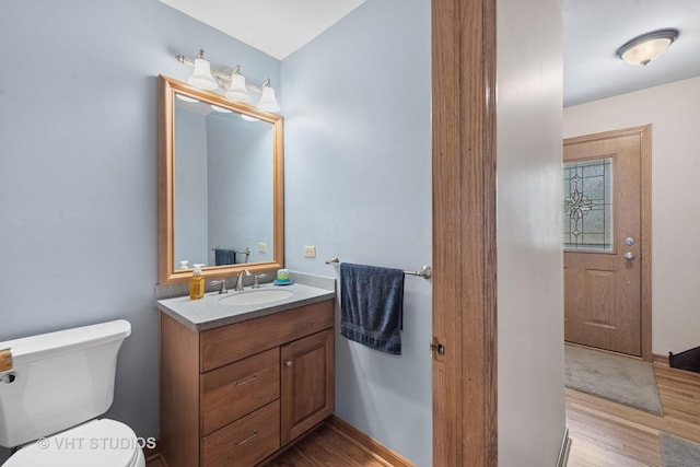 bathroom featuring vanity, toilet, and wood finished floors