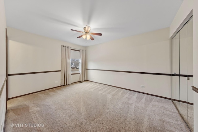 empty room with carpet flooring, ceiling fan, and baseboards