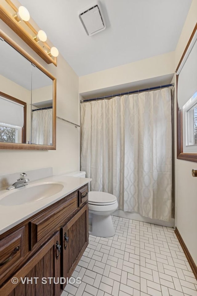 full bathroom with a wealth of natural light, visible vents, vanity, and toilet