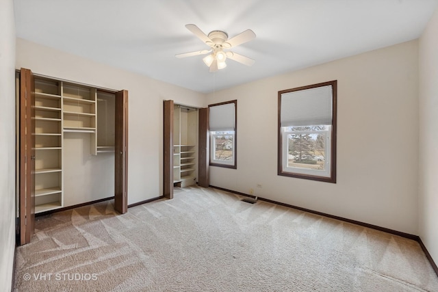 unfurnished bedroom with a ceiling fan, carpet, and baseboards