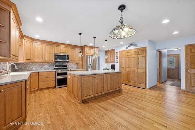 kitchen with stainless steel appliances, open shelves, a kitchen island, and a sink