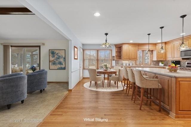 dining area featuring plenty of natural light, baseboards, light wood-style flooring, and recessed lighting