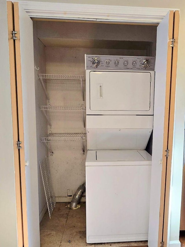 clothes washing area with laundry area and stacked washing maching and dryer