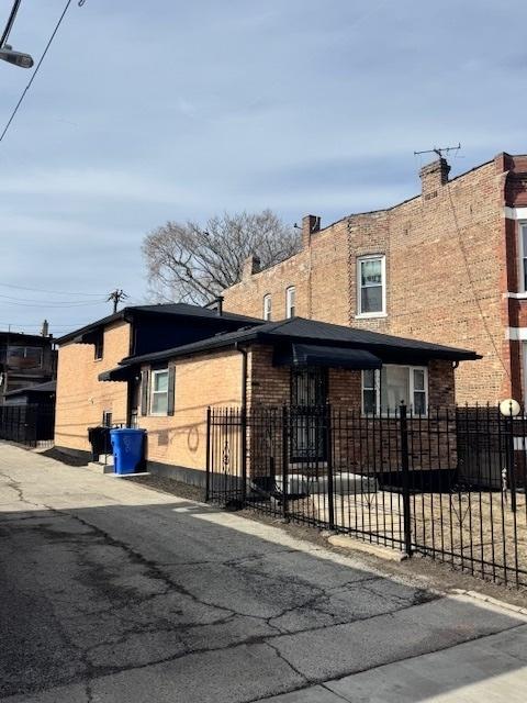 view of front of property featuring brick siding and a fenced front yard