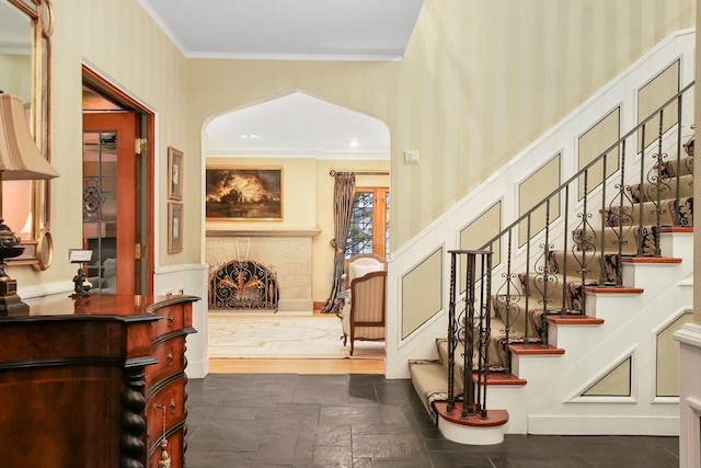 stairs featuring ornamental molding and a brick fireplace