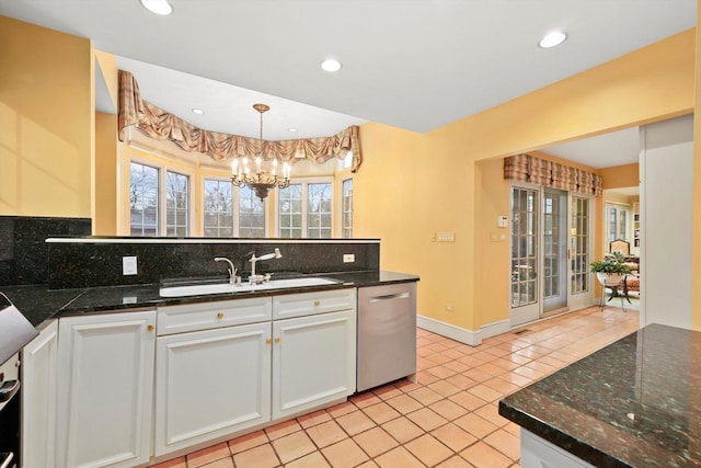 kitchen featuring a chandelier, a peninsula, a sink, stainless steel dishwasher, and backsplash