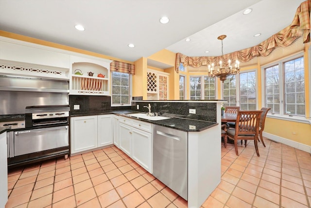 kitchen featuring white cabinets, backsplash, a peninsula, stainless steel dishwasher, and a sink