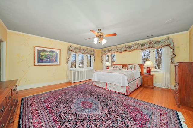 bedroom with multiple windows, wood finished floors, and radiator