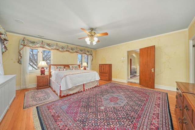 bedroom with multiple windows, baseboards, and wood finished floors