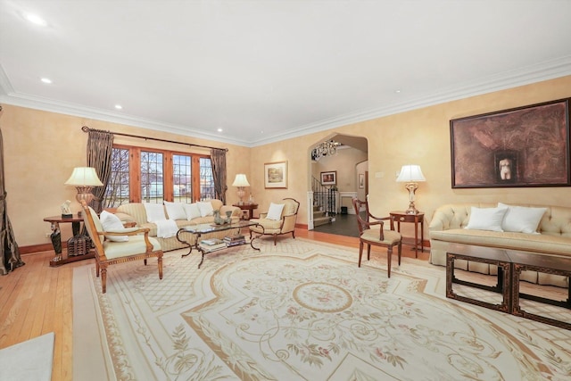 living room featuring baseboards, arched walkways, ornamental molding, hardwood / wood-style floors, and recessed lighting