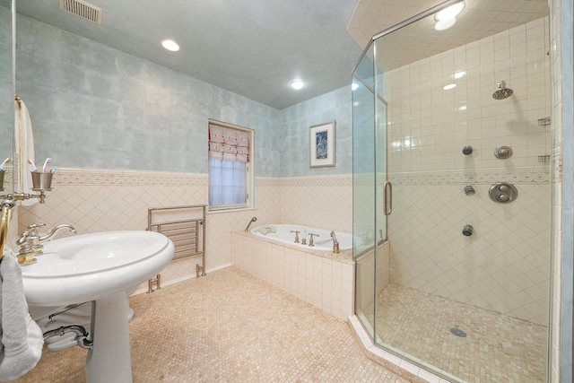 bathroom featuring tile patterned flooring, visible vents, wainscoting, a shower stall, and a bath