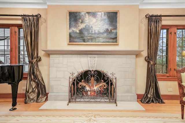 details with crown molding, a lit fireplace, baseboards, and wood finished floors