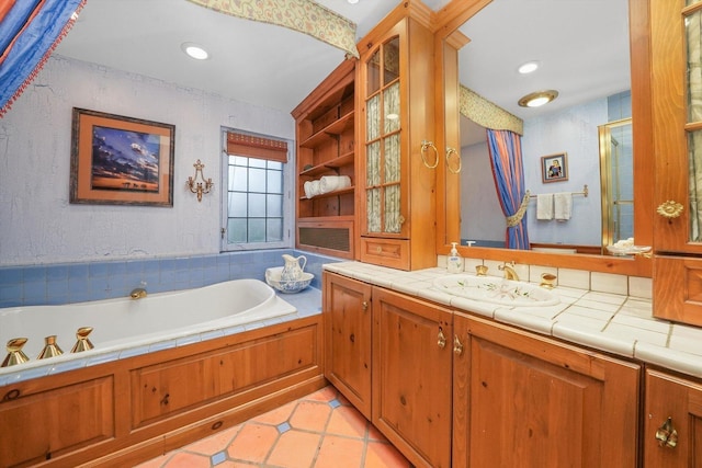 bathroom with recessed lighting, a garden tub, tile patterned flooring, and vanity