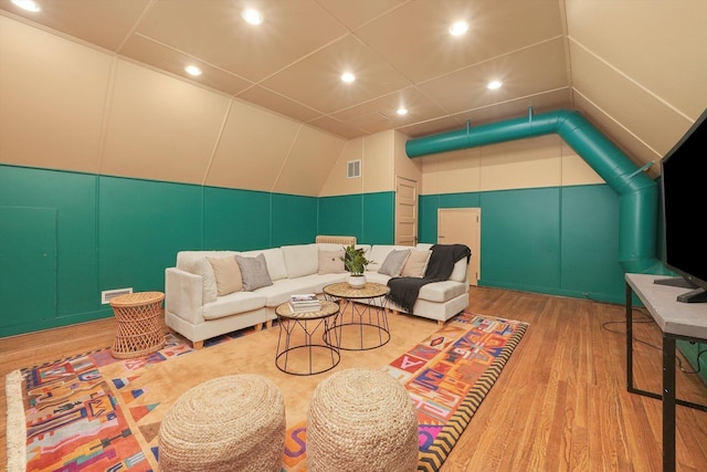 living area featuring recessed lighting, visible vents, a decorative wall, and wood finished floors