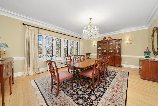 dining space with light wood-type flooring, a notable chandelier, baseboards, and crown molding