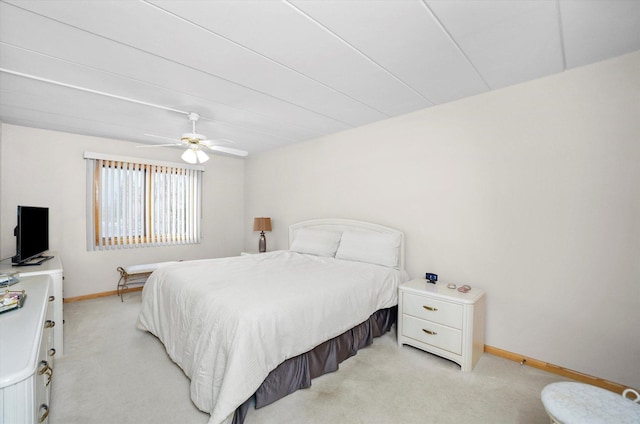 bedroom with light carpet, baseboards, and a ceiling fan