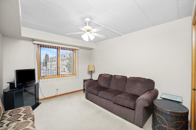 living room with ceiling fan, baseboards, and light colored carpet