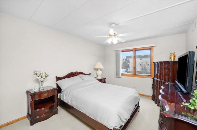 bedroom with a ceiling fan, light colored carpet, and baseboards