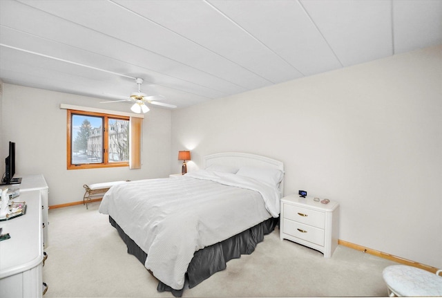 bedroom featuring light carpet, ceiling fan, and baseboards