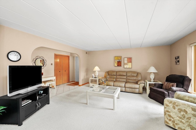 living room featuring arched walkways and light carpet