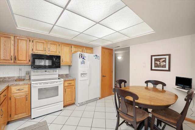 kitchen featuring light countertops, white appliances, light tile patterned flooring, and tasteful backsplash