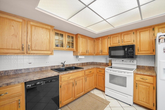 kitchen with light tile patterned floors, glass insert cabinets, a sink, black appliances, and backsplash