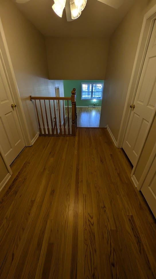 staircase with baseboards and wood finished floors