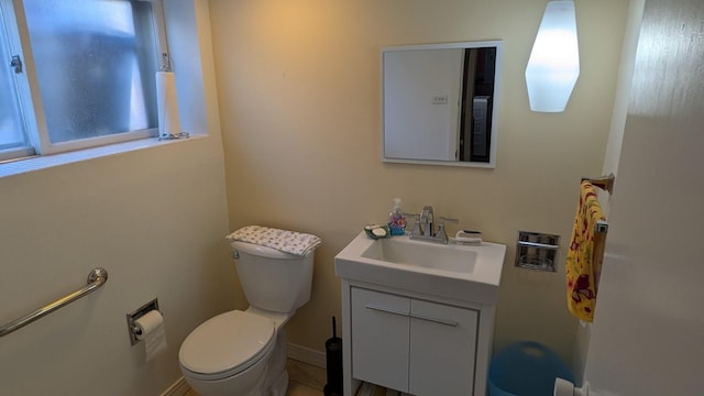 bathroom featuring baseboards, vanity, and toilet