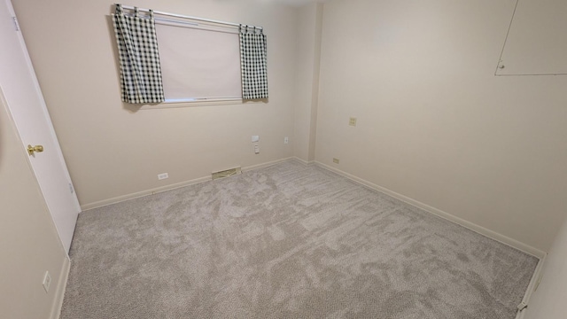 spare room featuring light carpet, baseboards, and visible vents