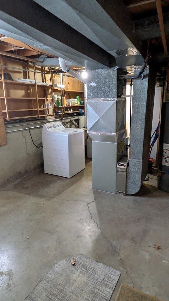 unfinished below grade area featuring gas water heater and heating unit