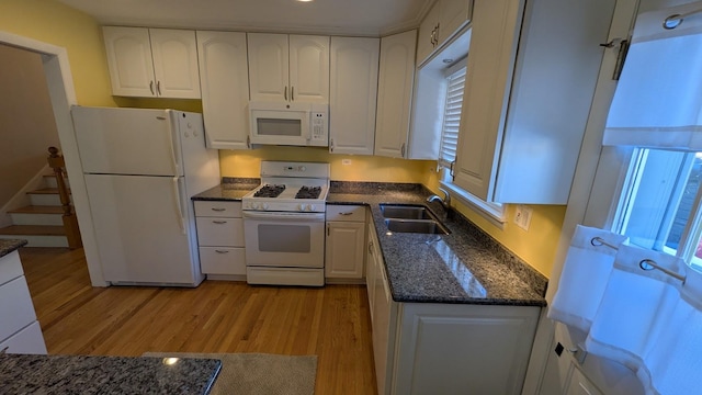 kitchen featuring white appliances, a sink, and white cabinets