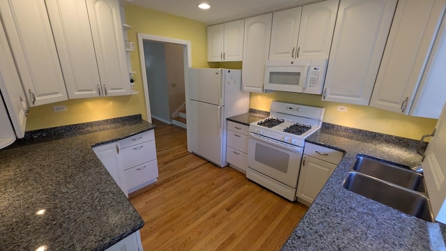 kitchen with recessed lighting, light wood-style floors, white cabinetry, a sink, and white appliances