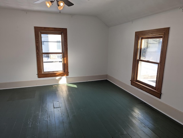 unfurnished room with lofted ceiling, ceiling fan, dark wood-style floors, and baseboards