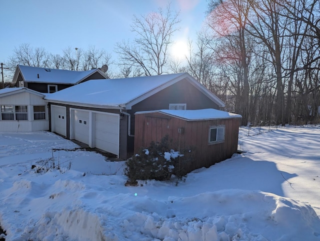 snow covered property with an attached garage