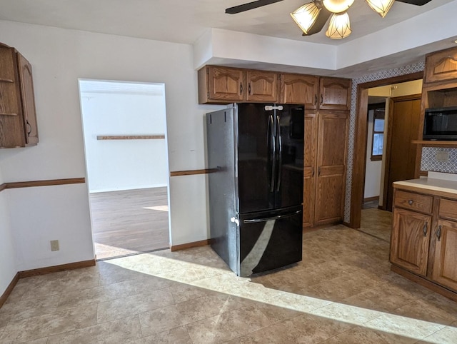 kitchen with ceiling fan, open shelves, baseboards, brown cabinets, and black appliances